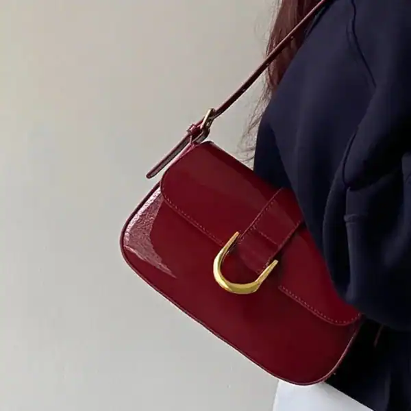 Vinröd lackväska med guldlock och axelrem, modeaccessoarer för kvinnor.