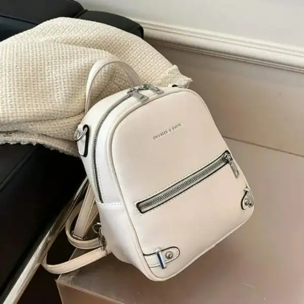 Vinröd liten ryggsäck i vitt läder, ideal för skola och vardag.