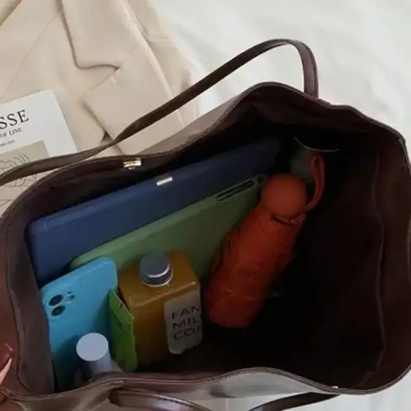 Vinröd shoppingväska med tablet, mobil och paraply i innehåll.