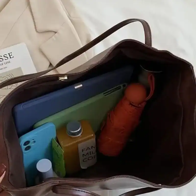 Vinröd shoppingväska med tablet, mobil och paraply i innehåll.