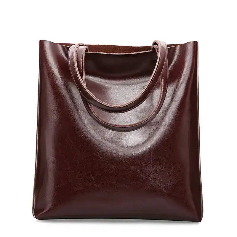 Vinröd läder tote bag med runt handtag och elegant design.
