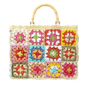 Färgglad virkad strandväska med granny square mönster och bambuhandtag.