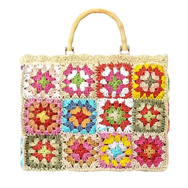 Färgglad virkad strandväska med granny square mönster och bambuhandtag.
