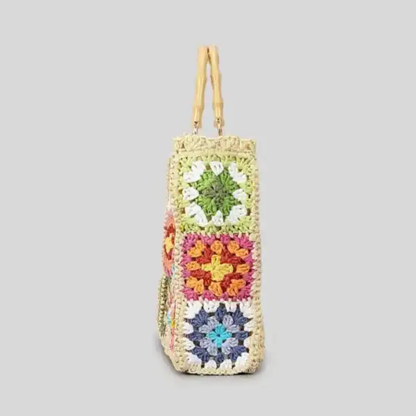 Virkad strandväska med färgglada granny square mönster och bambuhandtag.