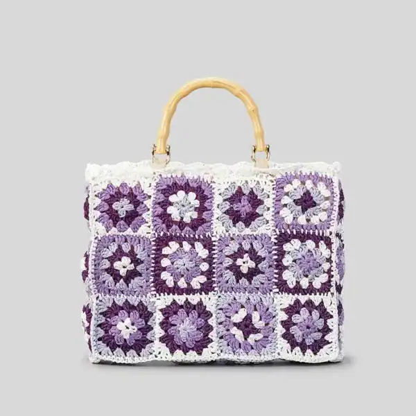 Virkad strandväska i lila och vit, med bambuhållare och granny square mönster.