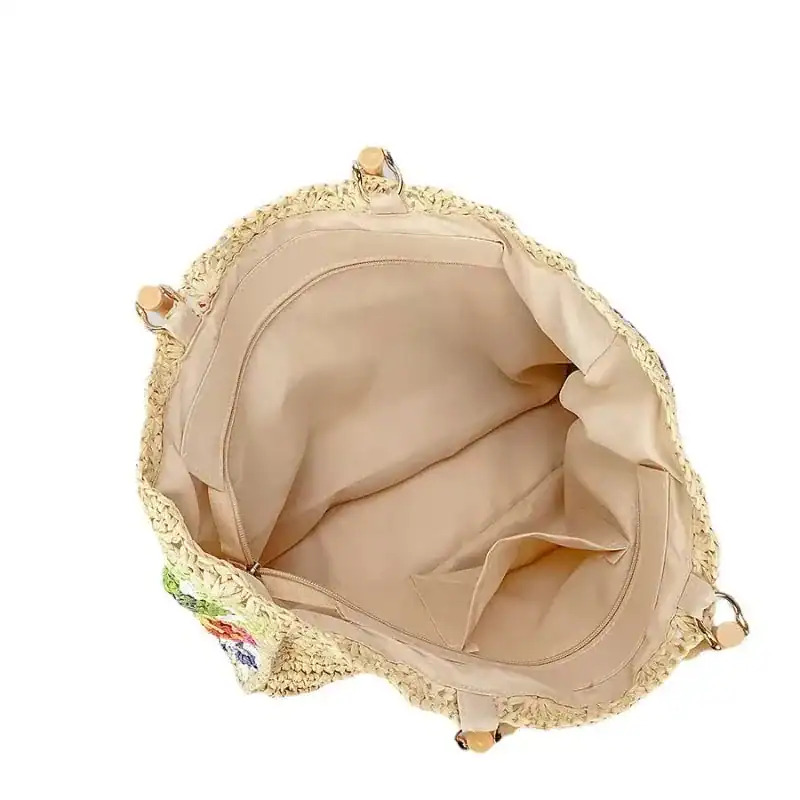 Virkad strandväska med beige inre och färgglada broderier.