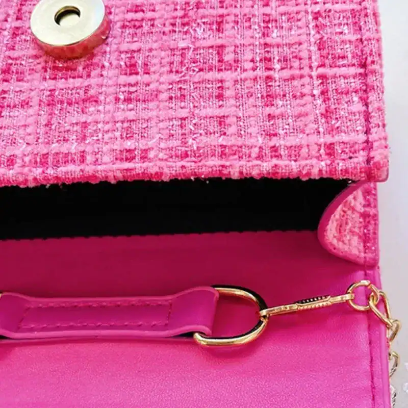 Vit barnväska med pärlor, rosa textil och guldtonad snäcka.