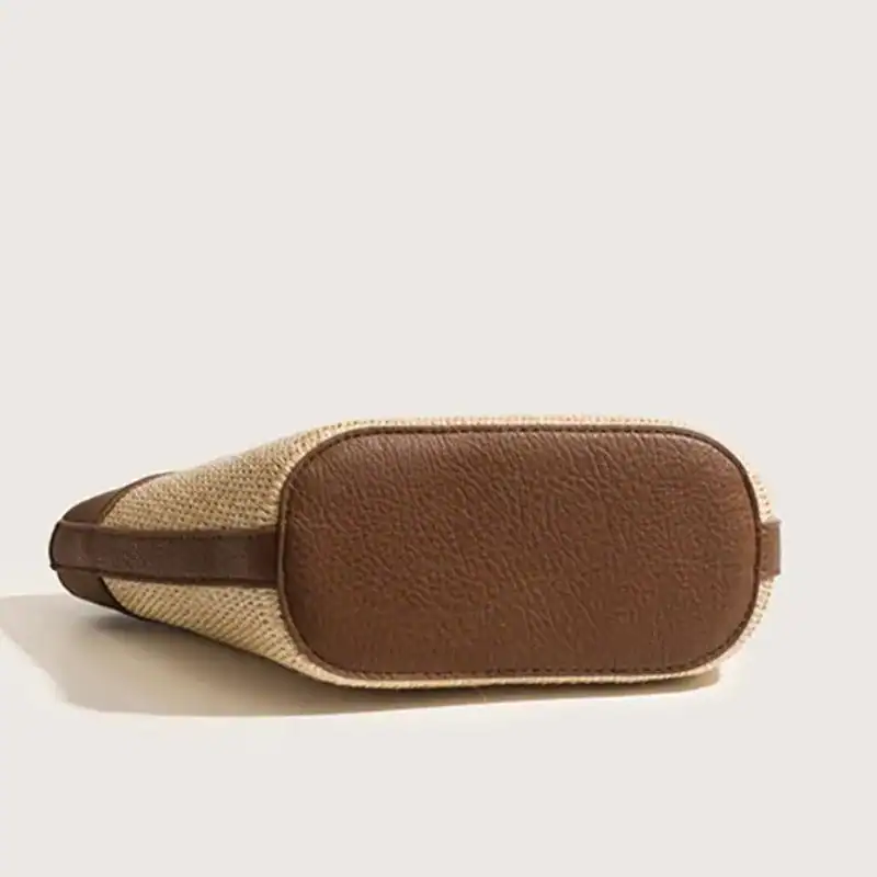 Vit beige stråväska med brunt läder, sidosikt.