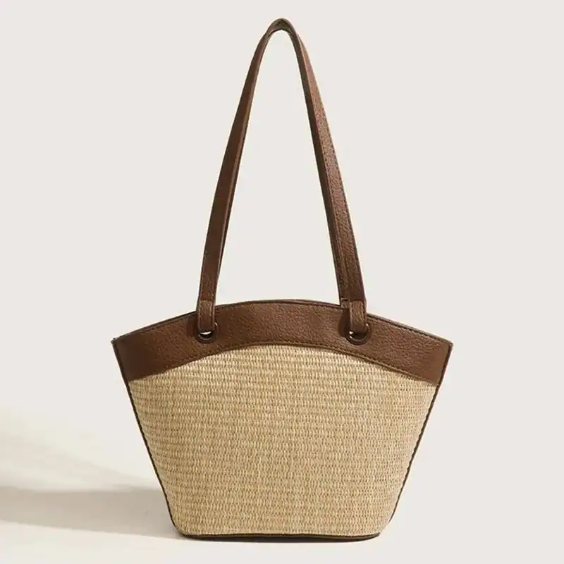 Vit beige stråväska med bruna handtag och elegant design.