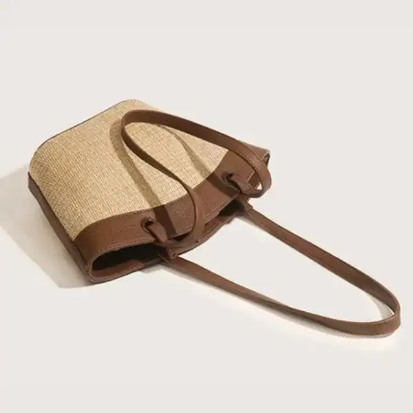 Vit beige stråväska med bruna handtag och axelrem, sommarmodell.