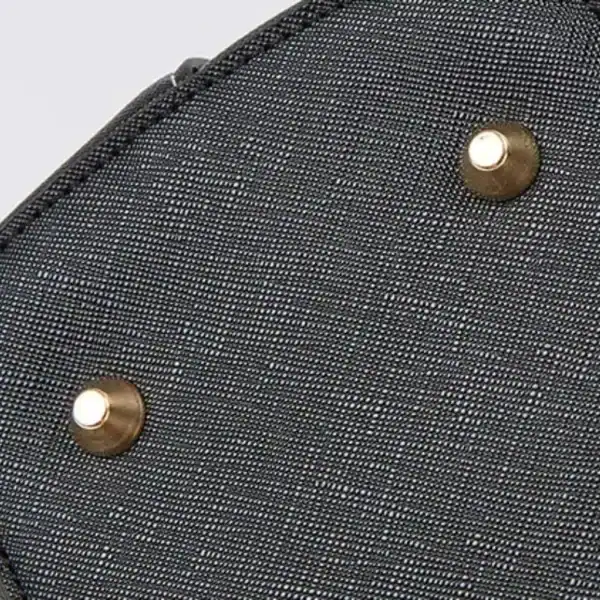 Vit beige väskset närbild, textilmaterial med metallknappar.