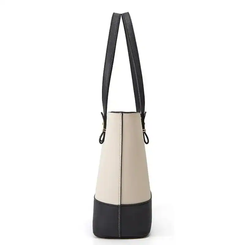 Vit beige väskset med svart handtag och kontrastnässor.