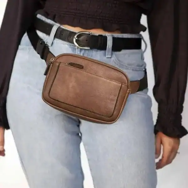 Vit brun bältesväska i läder, bärt på midjan med jeans och svart bälte.