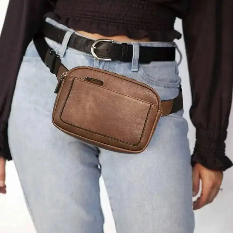 Vit brun bältesväska i läder, bärt på midjan med jeans och svart bälte.