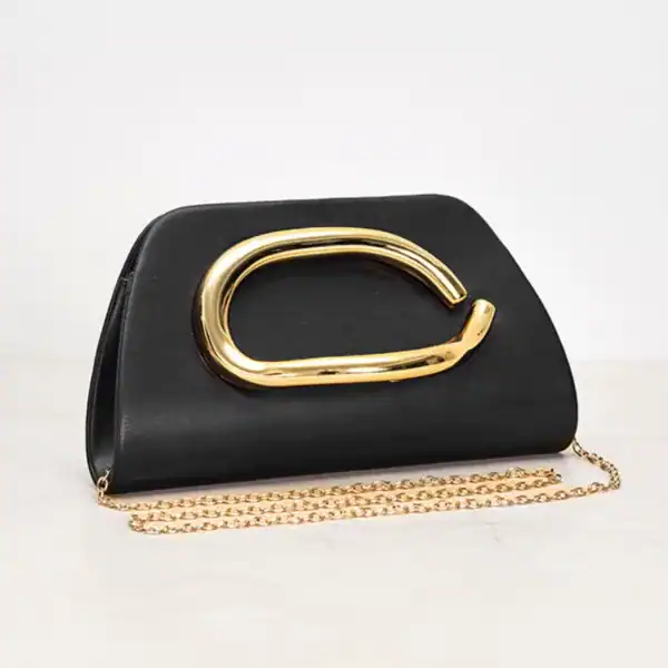 Svart clutch med guldhandtag och kedjehängare, elegant damväska.