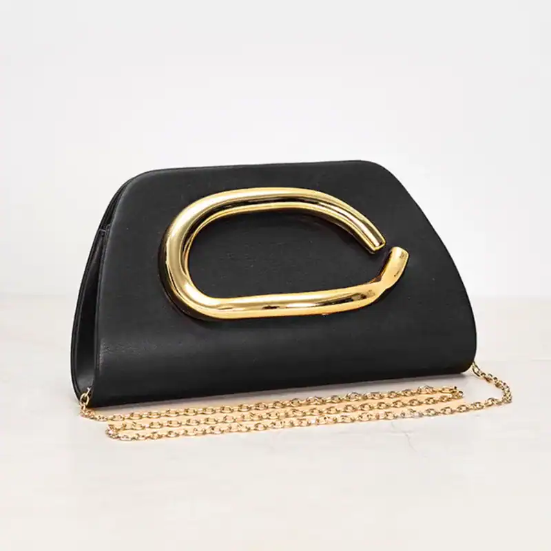 Svart clutch med guldhandtag och kedjehängare, elegant damväska.