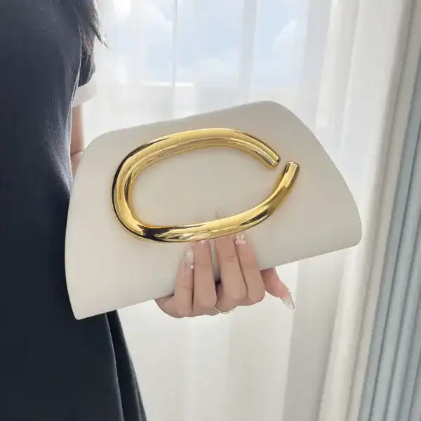 Vit clutch med guldhandtag, elegant axelväska för kvällsklänning.