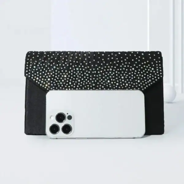 Svart glitterclutch med strass och iPhone för storlekskänsla.