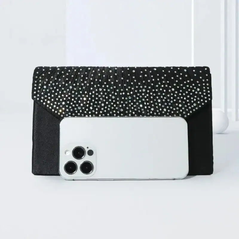 Svart glitterclutch med strass och iPhone för storlekskänsla.