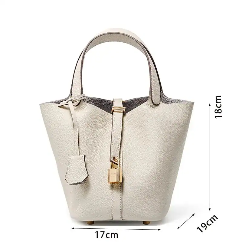 Vit hinkväska med lock, elegant axelväska i läder med guldaccent och mått 17x19x18 cm.