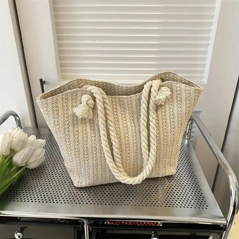 Vit korgväska med repband och tassar, lämplig för sommar och strand.