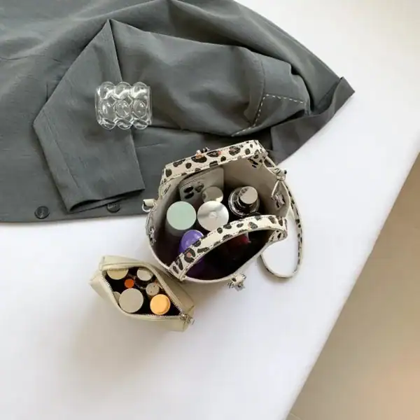 Vit leopard hinkväska med innehåll, stilig och praktisk för daglig användning.