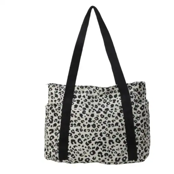 Vit leopard mönstrad axelväska med svarta handtag.