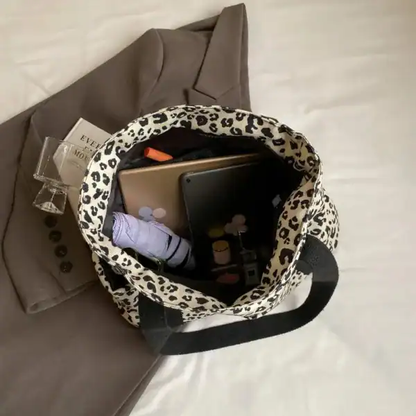 Vit leopard mönstrad axelväska med innehåll, lämplig för vardag och arbete.