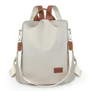 Vit nylon ryggsäck med bruna detaljer och axelremmar.