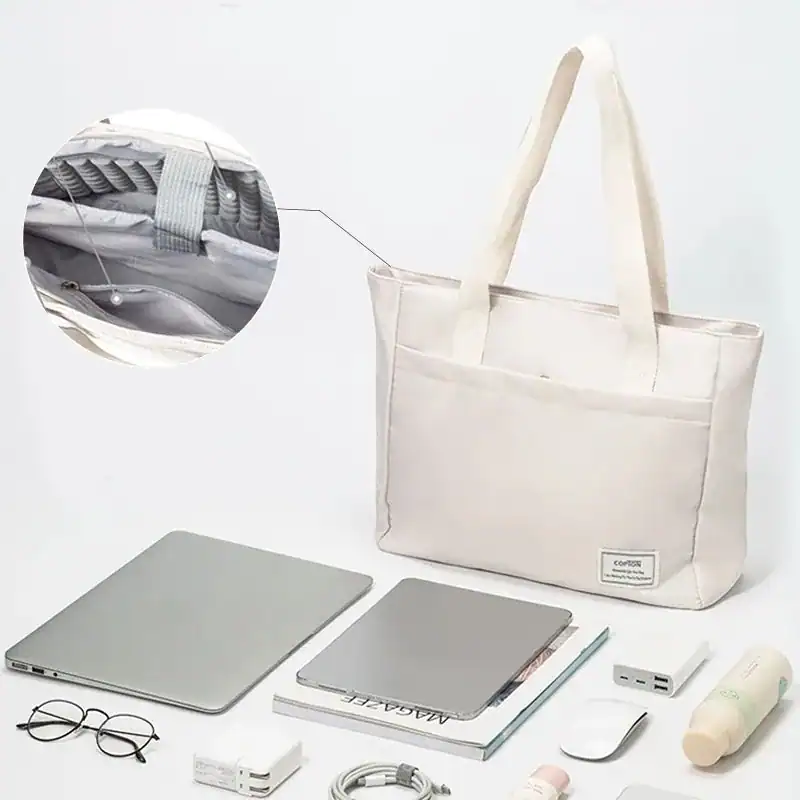 Vit tygväska dator med inbyggd struktur för säker lagring av bärbar dator.