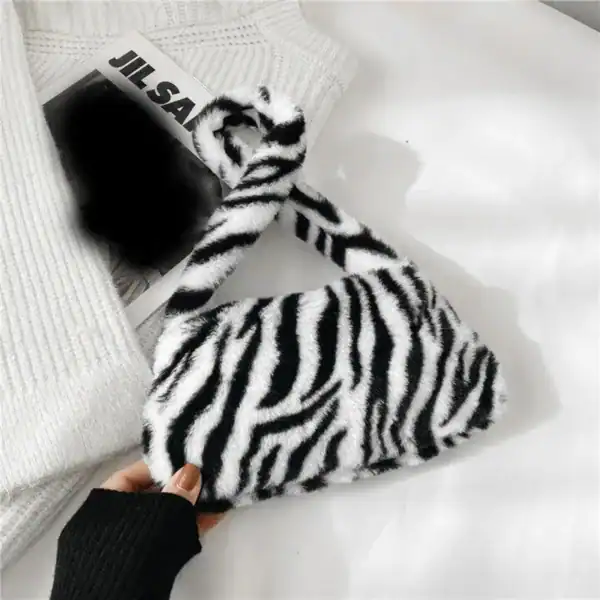 Zebramönstrad pälsväska i fluffig textil, trendig axelväska för kvinnor.